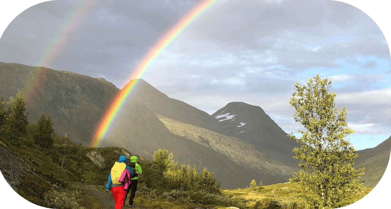 Picture of two people walking towards a rainbow